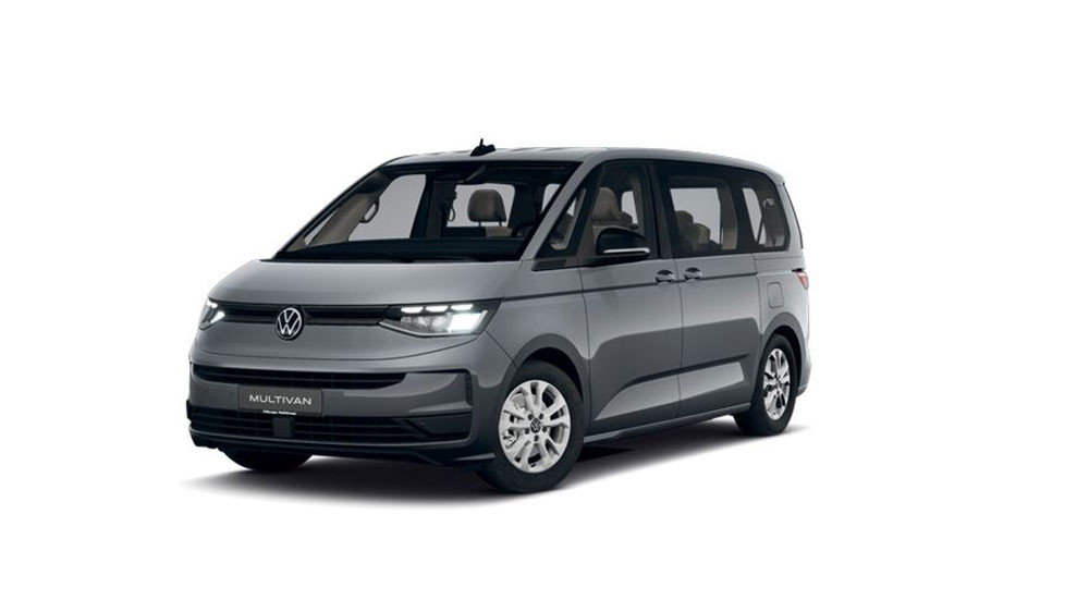 Ein silbergrauer Kleinbus mit klaren Konturen steht vor weißem Hintergrund. Die Frontpartie zeigt einen schmalen Kühlergrill mit horizontalen LED-Leuchten und das Volkswagen-Logo mittig. Die Seitenfenster sind großflächig, die Karosserie wirkt kantig und modern. Die Felgen sind schlicht gestaltet, die Türgriffe liegen flach an. Auf dem Kennzeichen steht 'MULTIVAN'.